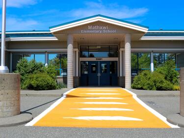 Mathxwí Elementary Exterior Image with orange crosswalk in front